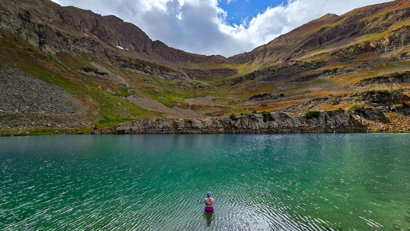A woman standing in a beautiful mountain lake