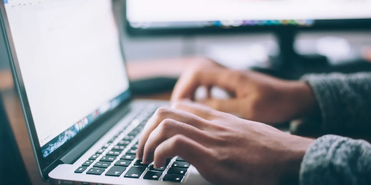 A person typing on a laptop - photo by Glenn Carstens Peters